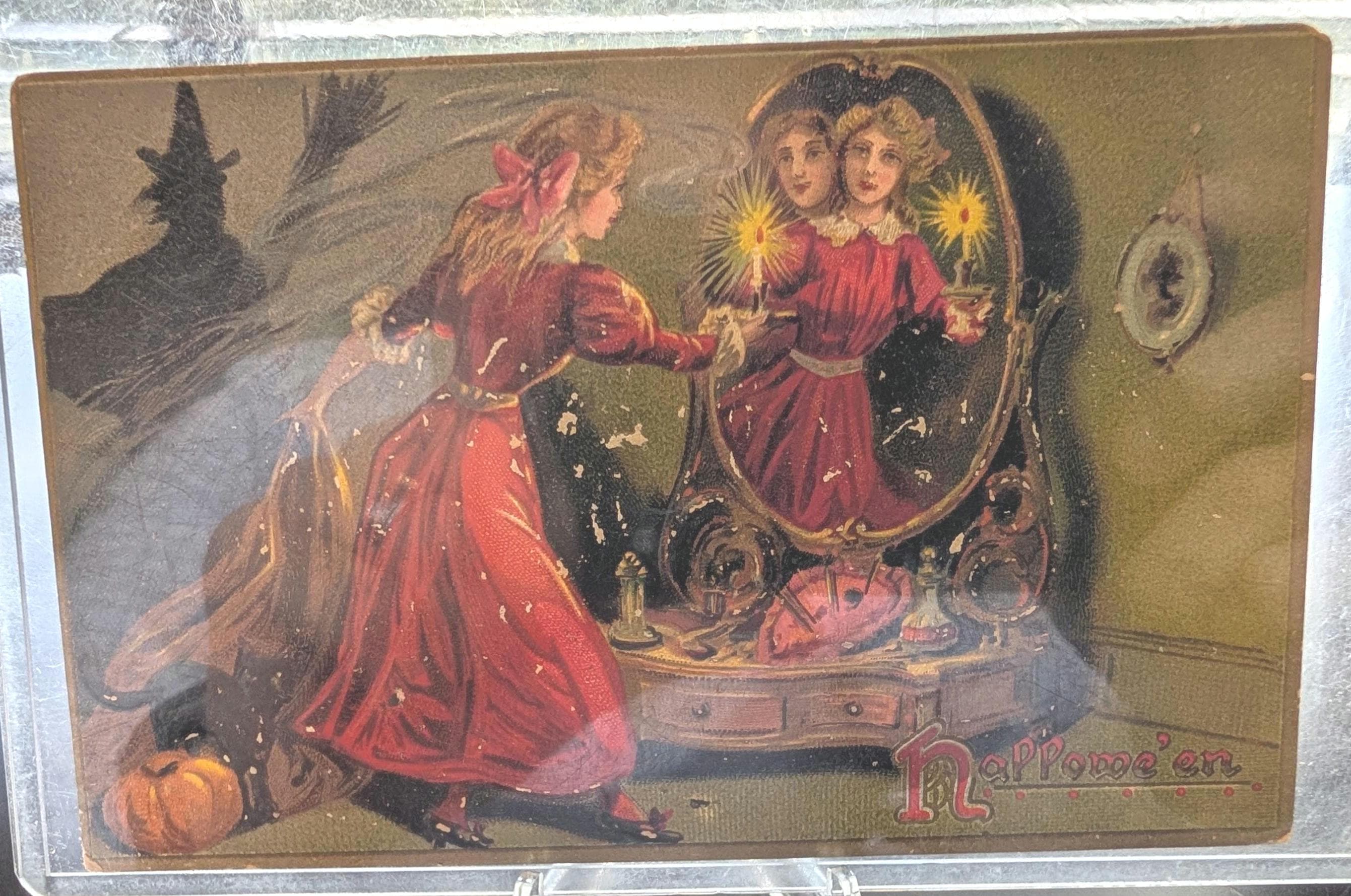 1908 Raphael Tuck Halloween postcard showing a woman at a mirror with a witch's reflection and a black cat